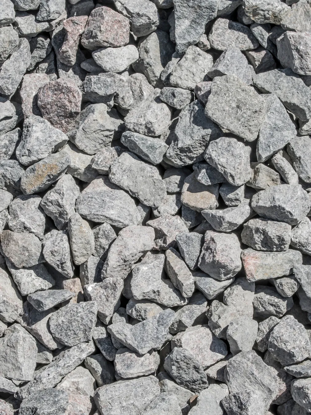 Close-up of a pile of irregular gray and light pink stones.