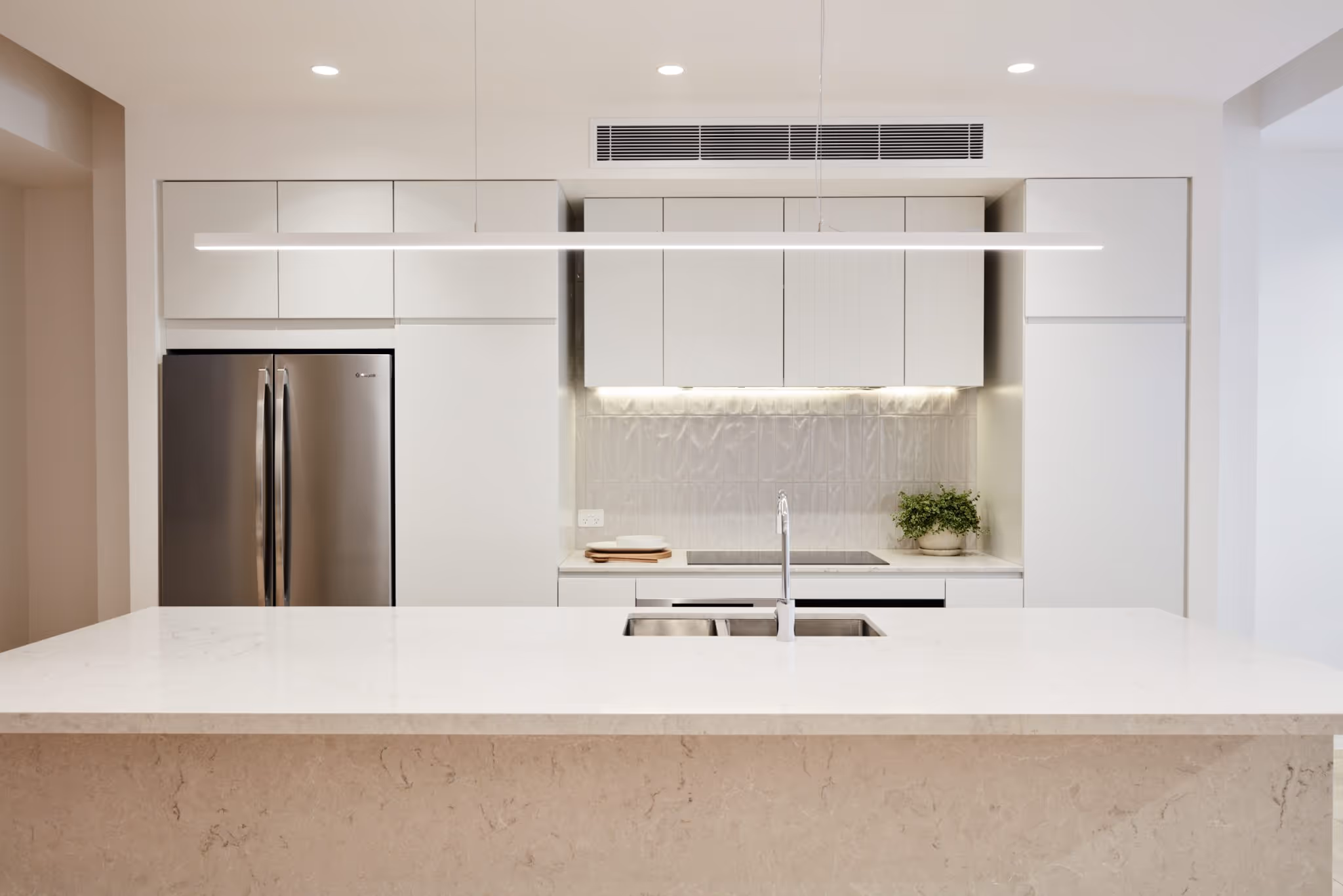 A kitchen with a refrigerator and a sink.