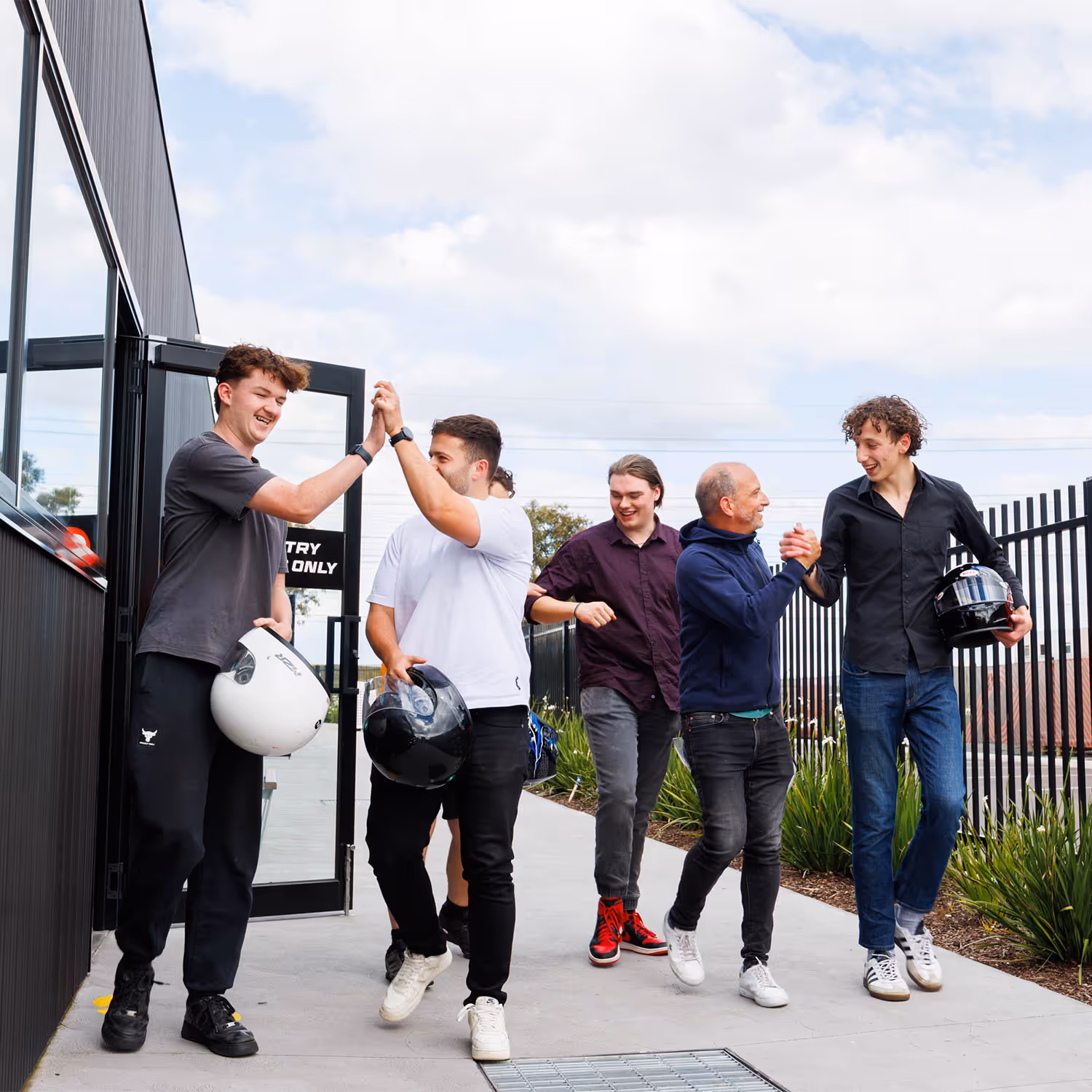 Racer beside go-karts giving a thumbs up at Ace Karts bucks party.