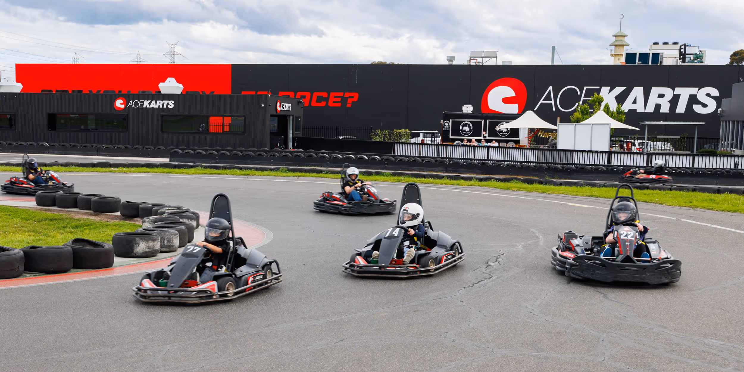 Children wearing helmets at Ace Karts preparing for a kids party race.