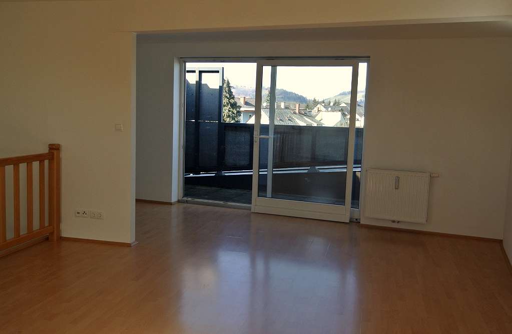 Wohnzimmer mit großer Fensterfront und Zugang zur Loggia mit Ausblick auf Leibnitz