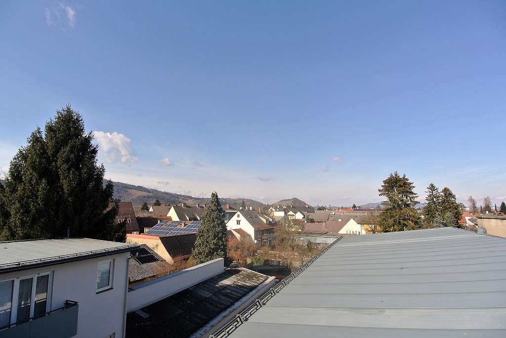 Weitläufiger Ausblick über die Dächer und Hügel der Umgebung von Leibnitz