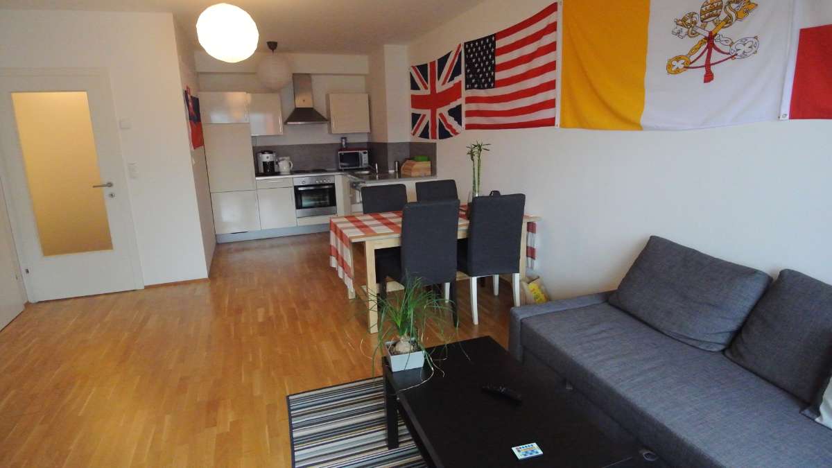 Offener Wohn- und Küchenbereich mit Esstisch und Sofa