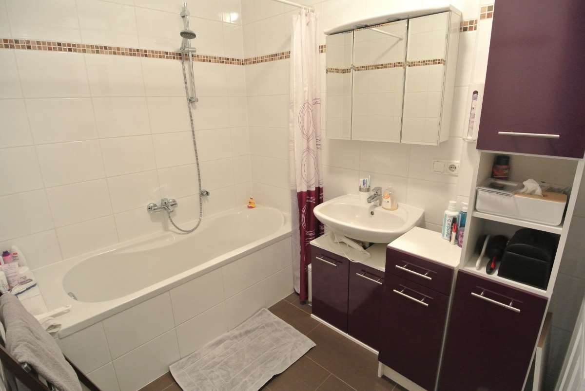 Badezimmer mit Badewanne, Dusche, Waschbecken und Spiegel