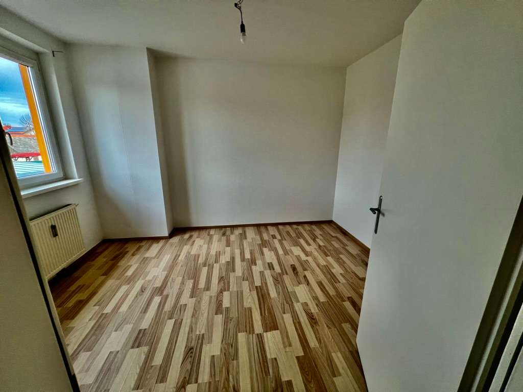 Weiteres Zimmer mit Laminatboden, Fenster und Heizkörper