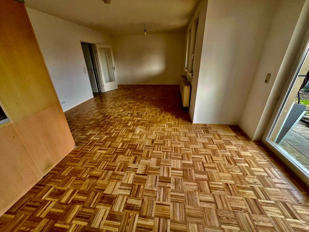 Wohn- oder Essbereich mit Parkettboden und Zugang zur Terrasse