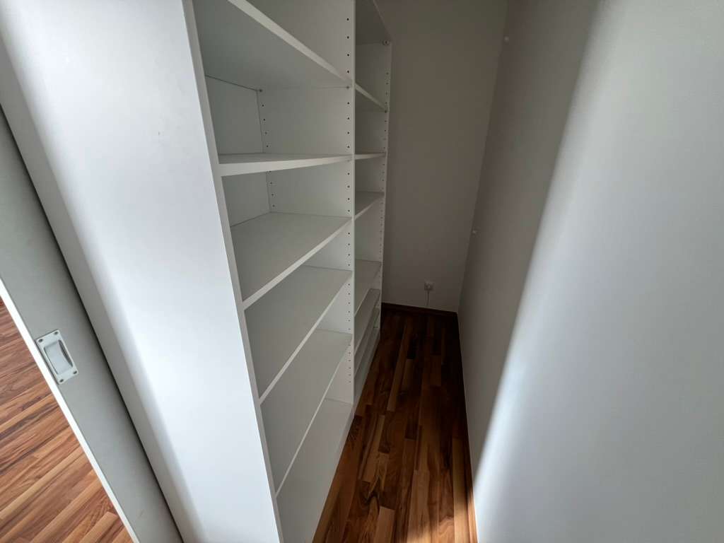 Schmaler Abstellraum oder Speisekammer mit weißen Regalen