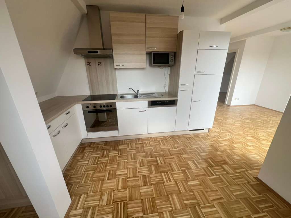 Moderne offene Einbauküche mit Holz- und Weißfronten im Wohnbereich