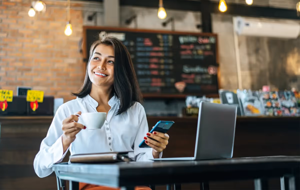 Small business owner smiling in Los Angeles café — AllSafe IT managed IT services client