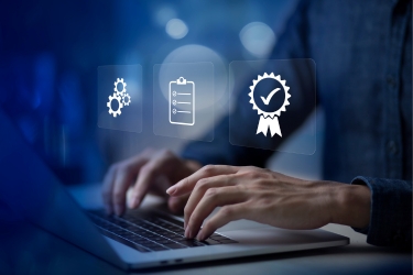 Hands on a laptop documenting certifications, records, checklists and more.