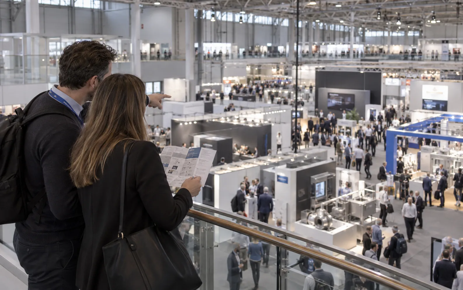 Generated scenario: exhibitor colleagues scouting an industry exhibition with an event guide