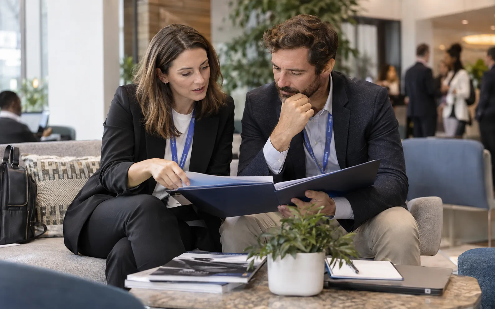 Generated scenario: A marketer and sales colleague align around an account research folder in a venue lounge rather than passing a disconnected spreadsheet