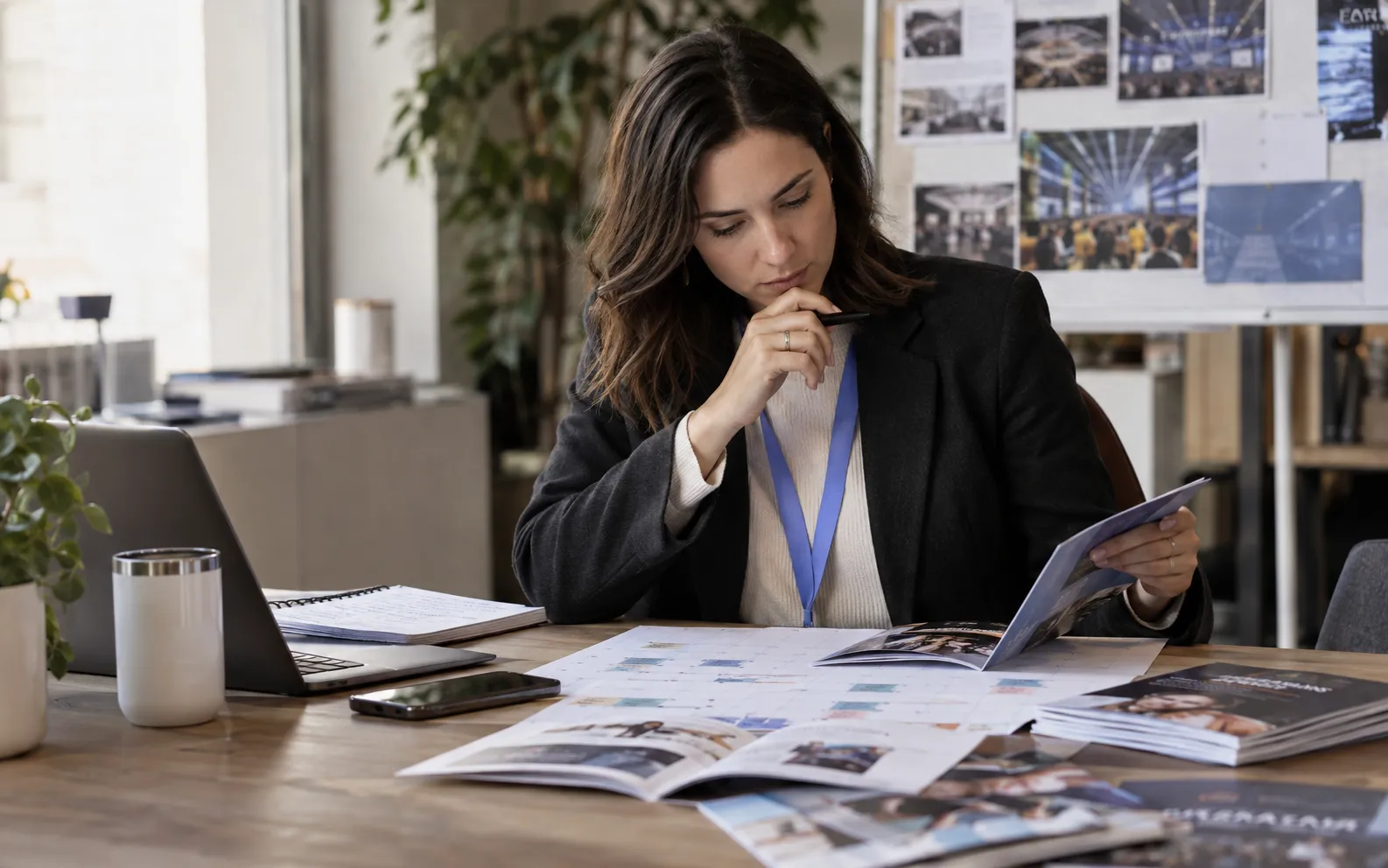 Generated scenario: An event marketing manager compares a busy printed exhibition calendar with company audience brochures at a planning table