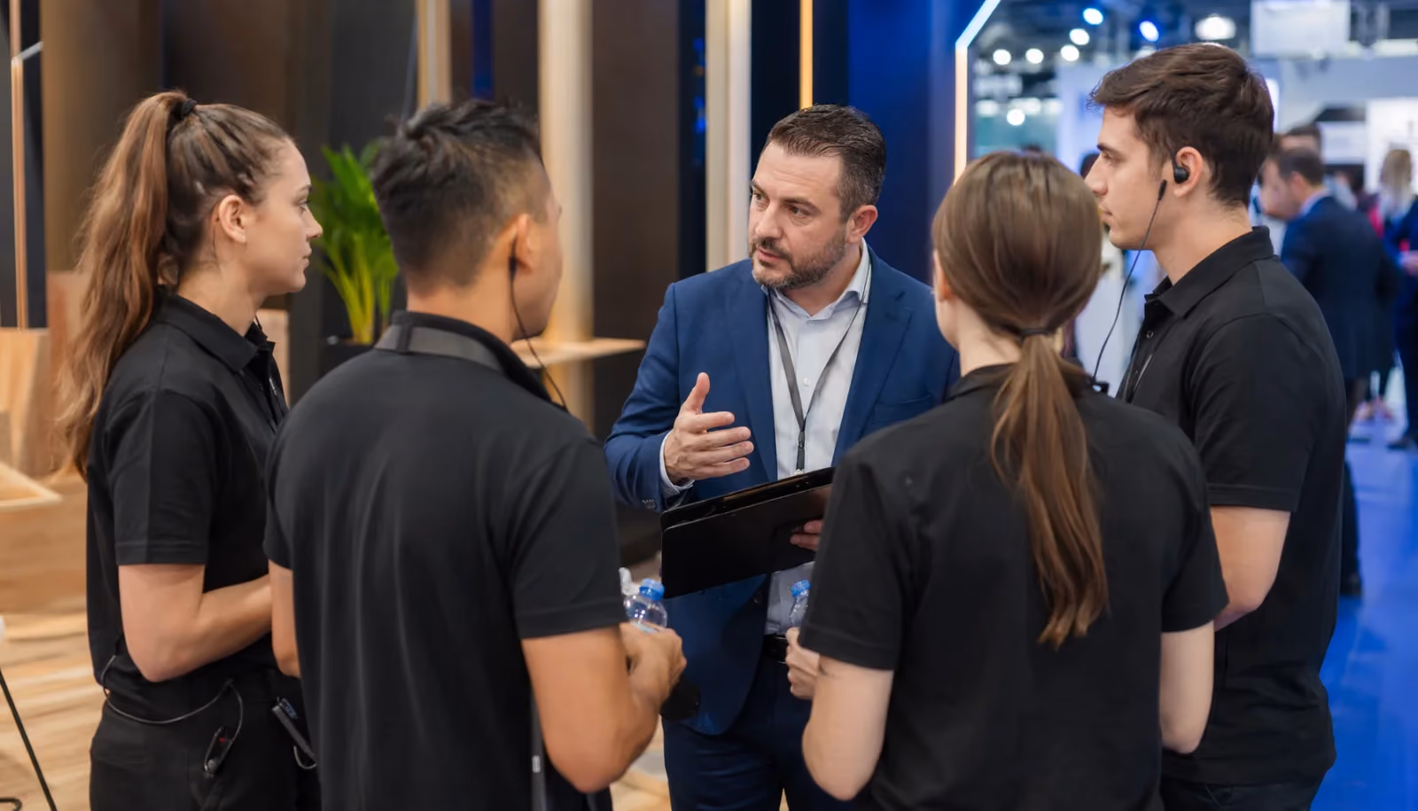 Ein Koordinator für Eventpersonal weist Markenbotschafter vor Öffnung einer Messe ein.