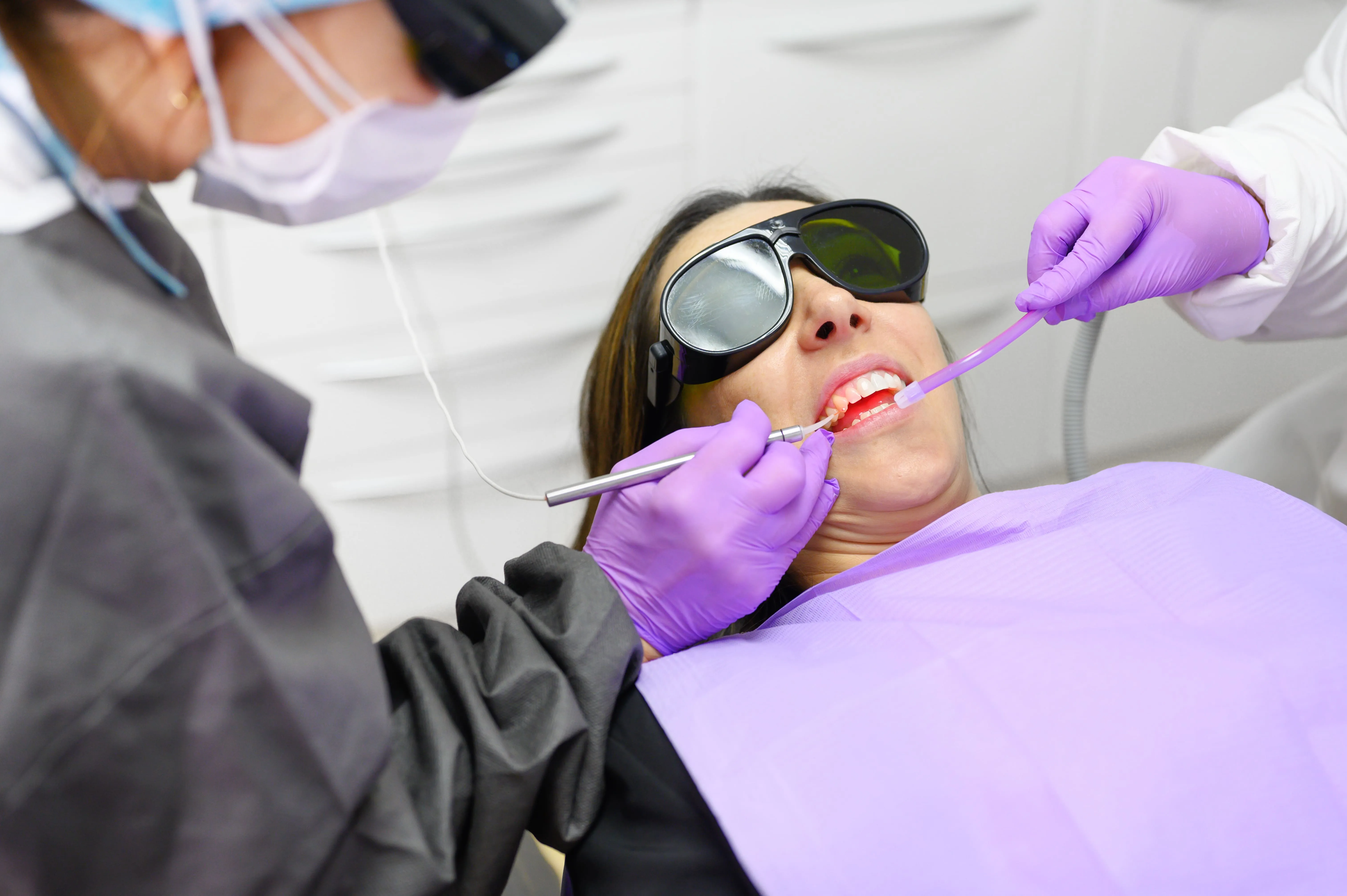 Dental team examining a patient before oral laser treatment