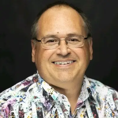 Middle-aged man with glasses wearing colorful floral patterned shirt, smiling portrait