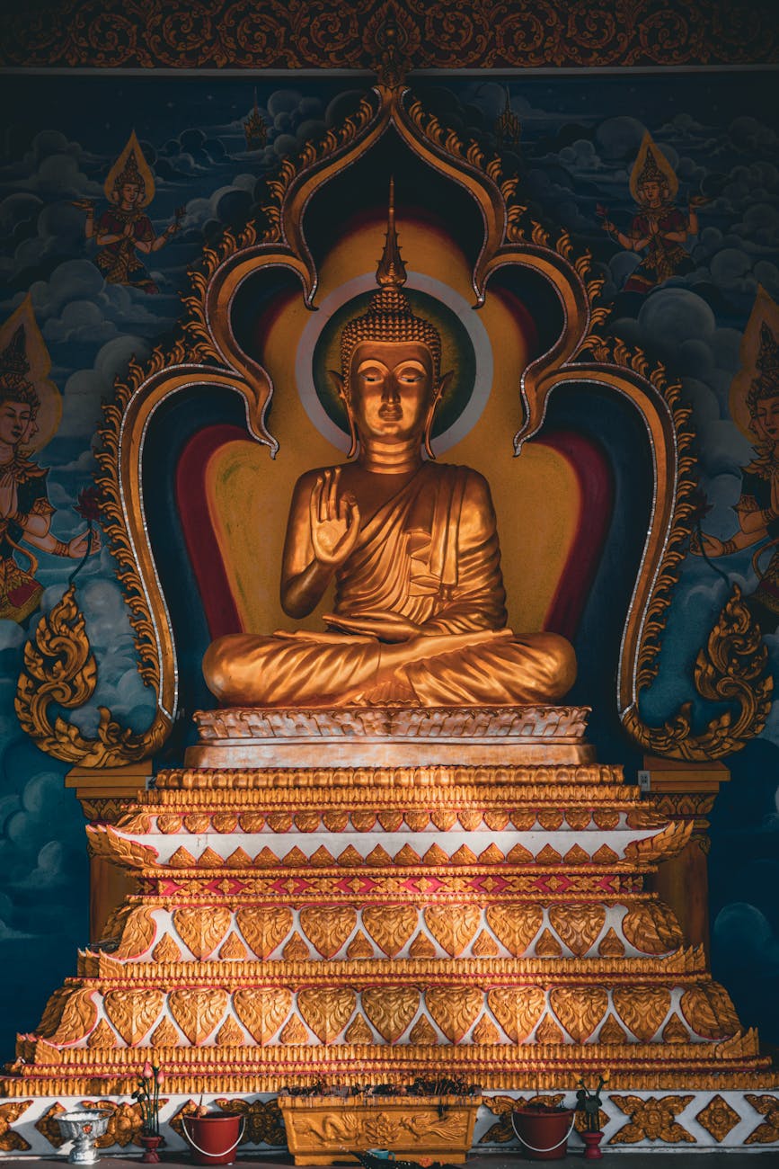 An ornate golden Buddha statue in a richly decorated temple setting, conveying peace and spirituality.