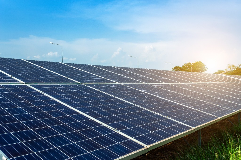 Rows of rooftop solar panels under a bright sky