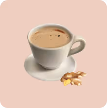 White cup filled with tea on a white saucer with ginger root beside it on a light pink background.