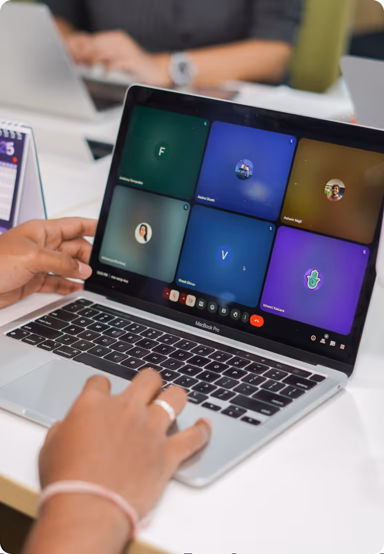 Person joining a video conference on a MacBook Pro showing six participants in a grid.