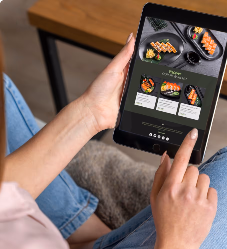 Person holding a tablet displaying a sushi restaurant's new menu with images of sushi dishes and descriptions.