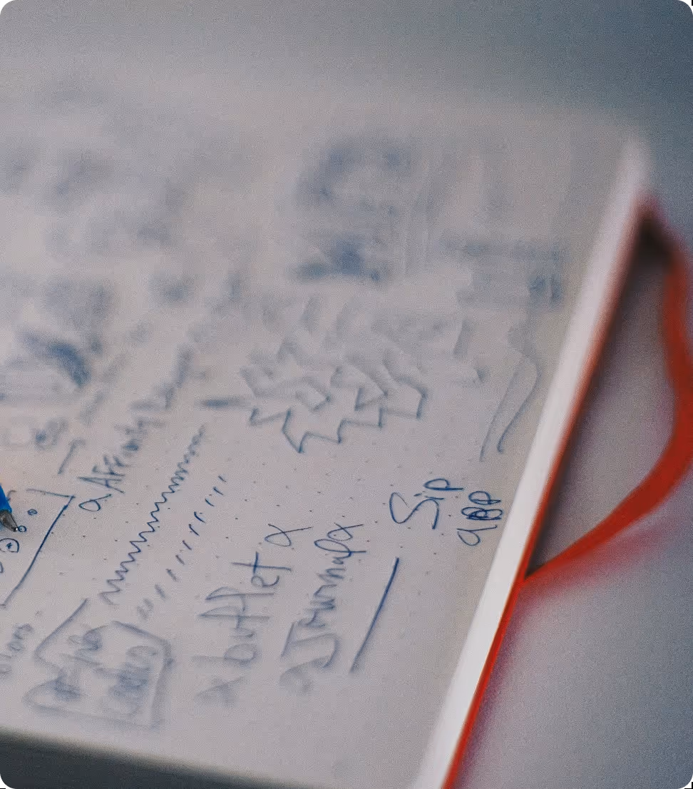 Close-up of a notebook page with handwritten notes, sketches, and diagrams in blue ink.