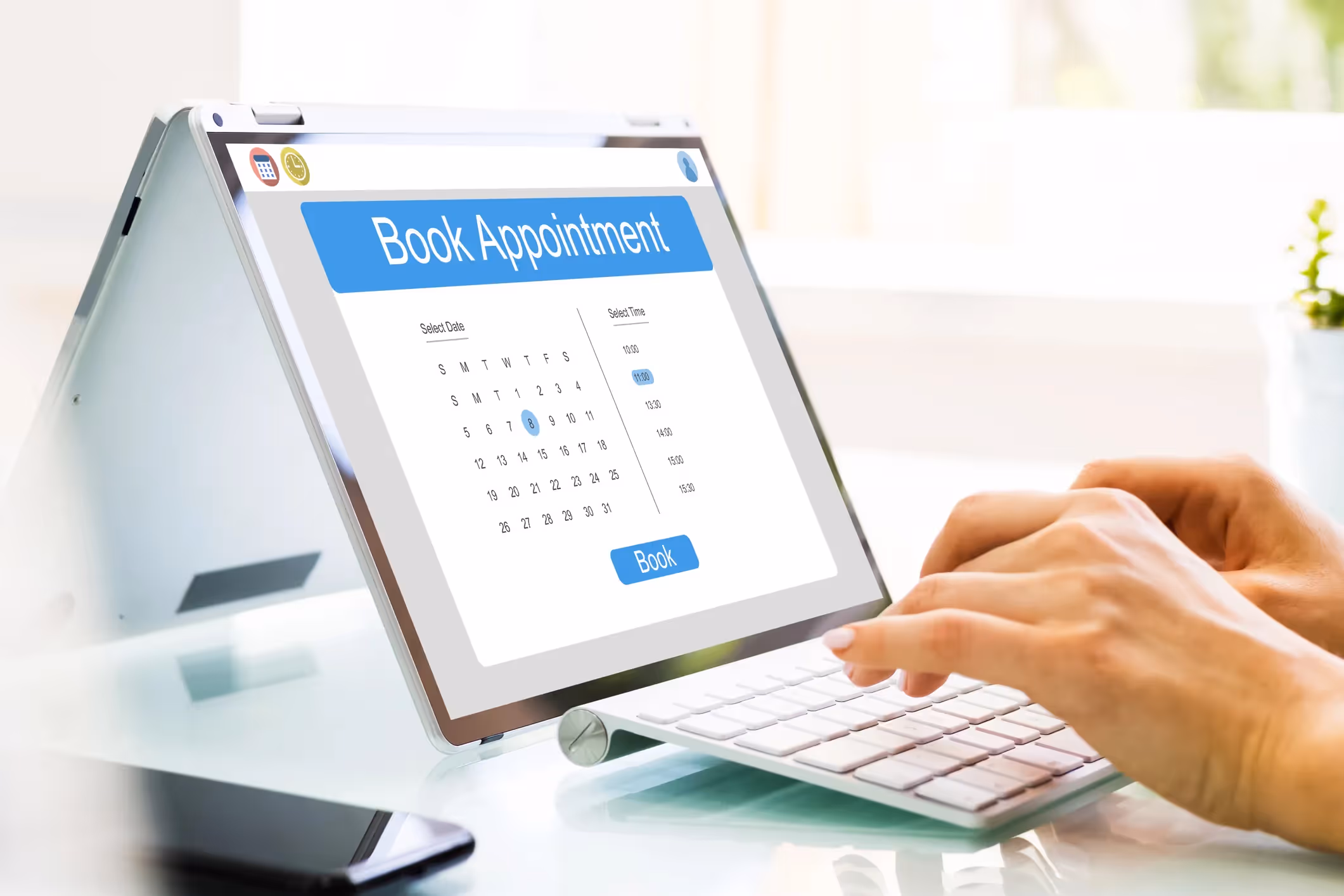 Hands typing on a keyboard to book an appointment online via a calendar.