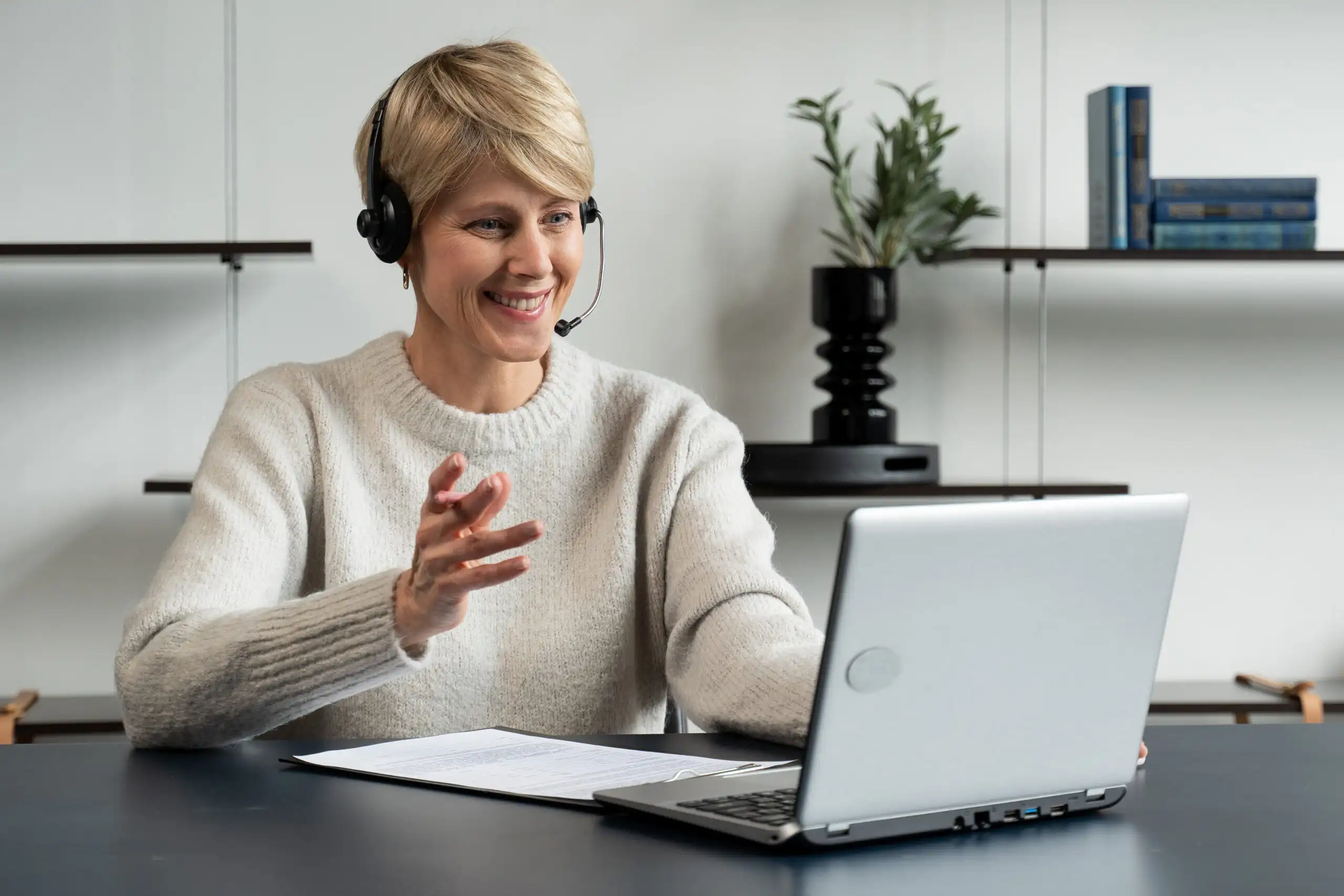 Smiling woman on video call using laptop.