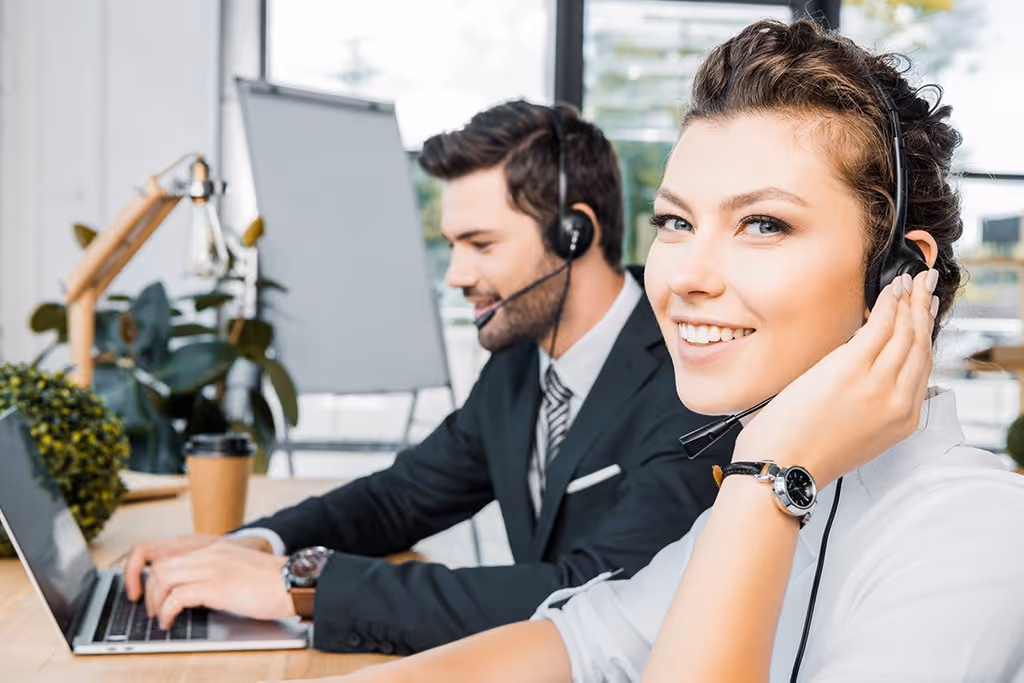 Professional customer service representatives in an office setting, using headsets and laptops, illustrating the benefits of an answering service in Albany, NY.