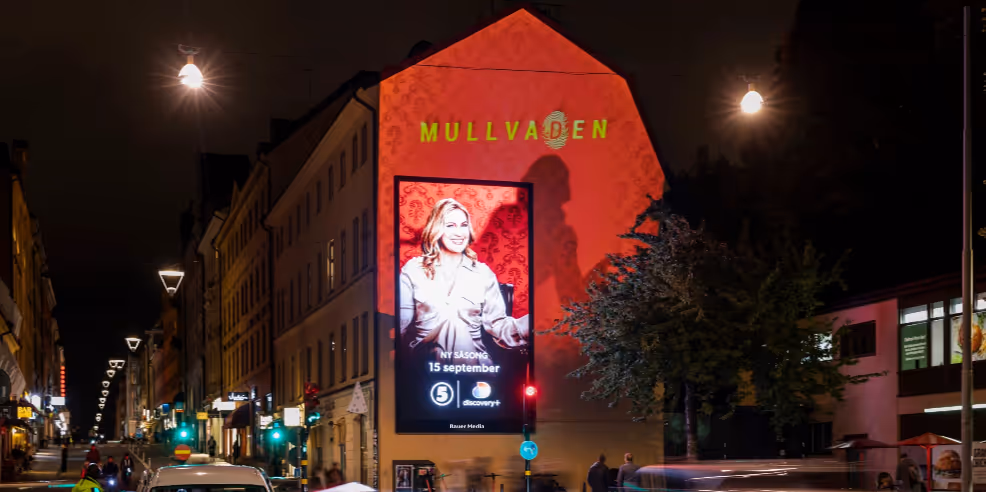 A digital screen and a projection work together to create an advert on the wall.
