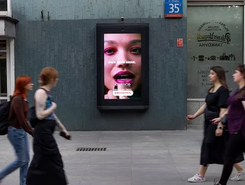 4 girls walk past a makeup digital poster advert