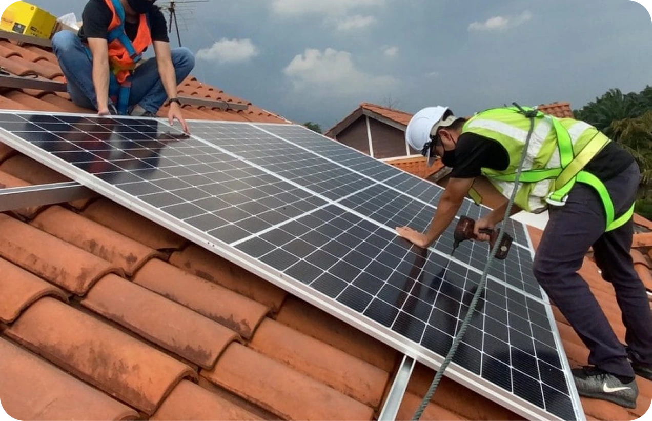 Rural building with solar panels on roof, various equipment outside, under a partly cloudy sky.
