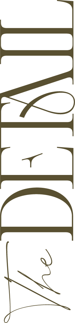 Vertical stylized text reading 'the Detail' written in cursive intersecting the letters.