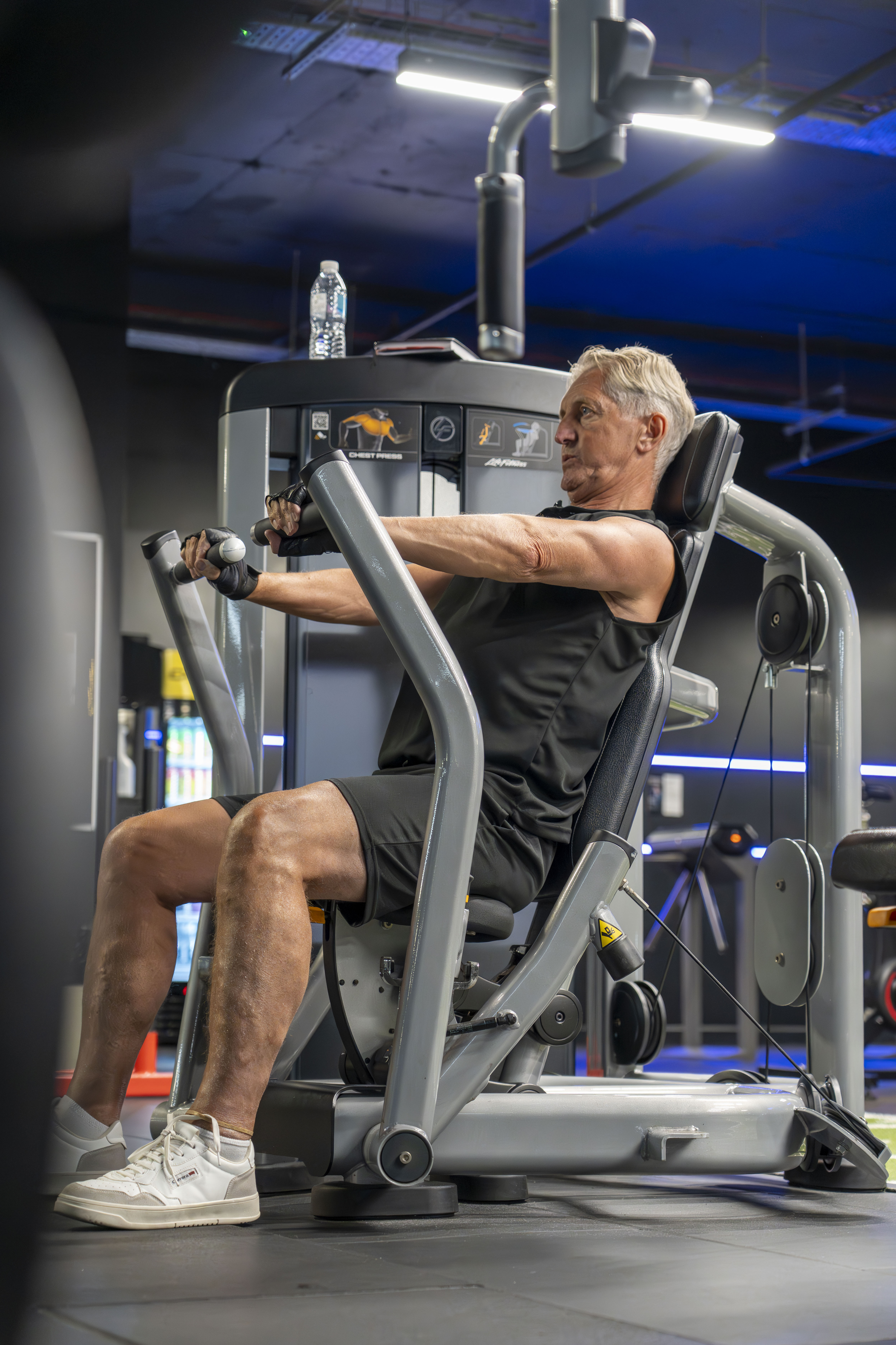 Member using leg press in fully equipped gym