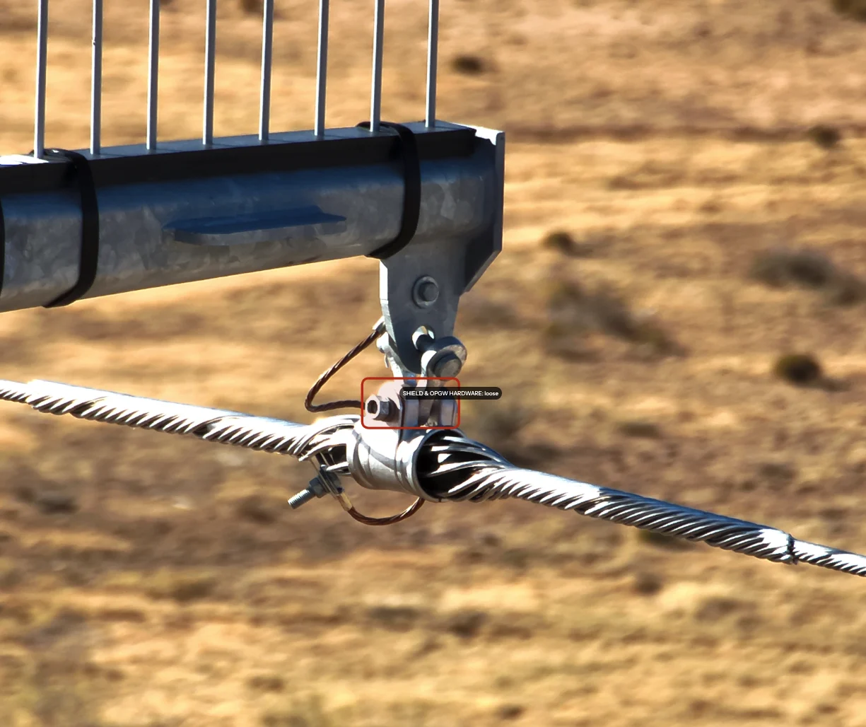 An annotated finding on a captured frame - shield and OPGW hardware flagged loose