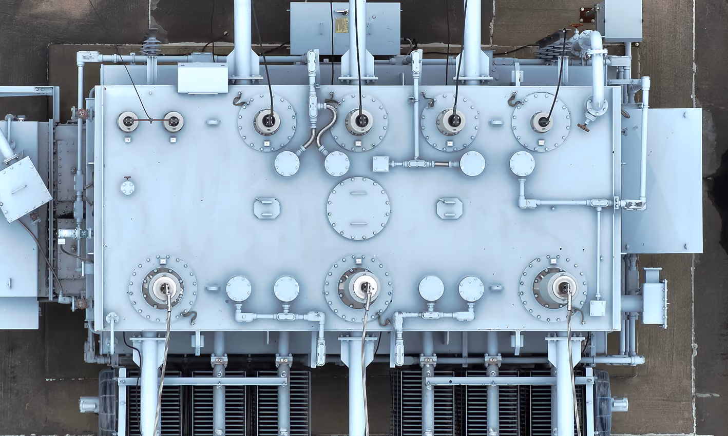 Aerial top-down view of a substation transformer with bushings and radiator banks