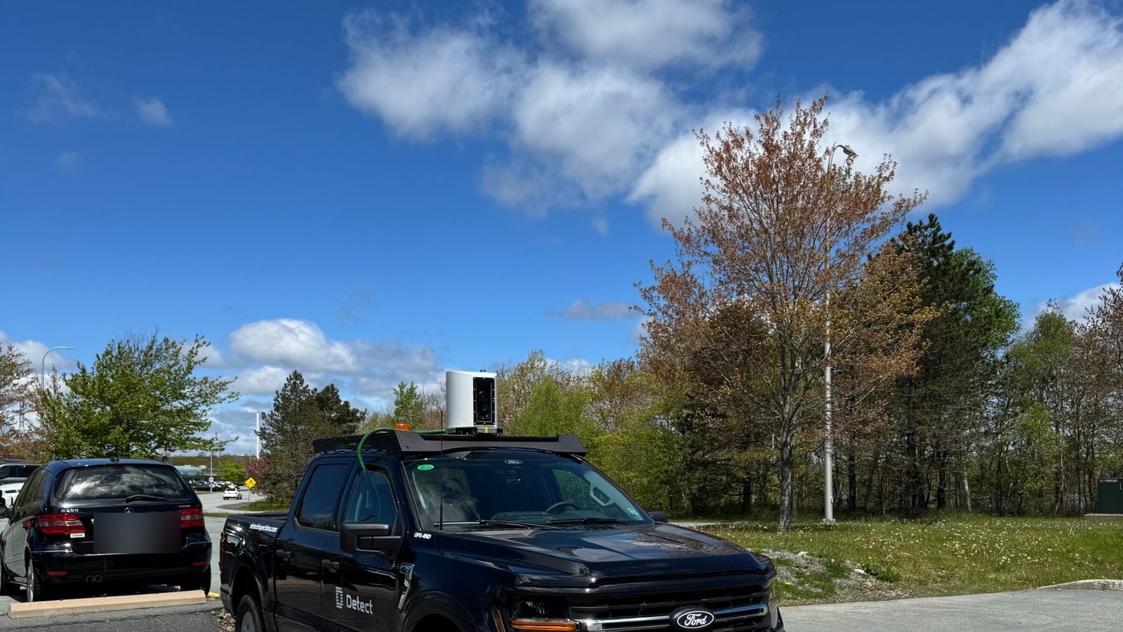 Detect survey truck with a sealed, roof-mounted camera enclosure for utility pole data collection at road speed