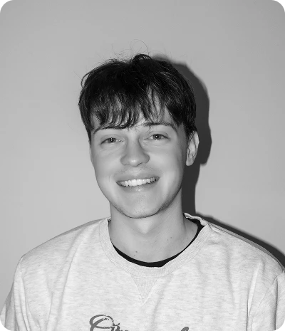 Jeune homme souriant portant un sweat-shirt clair avec un fond uni.