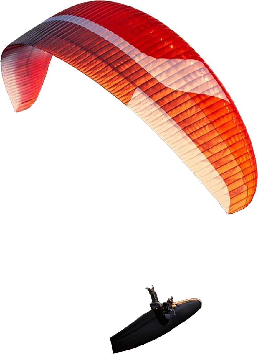 Une personne en parapente avec une voile rouge et blanche en plein vol.