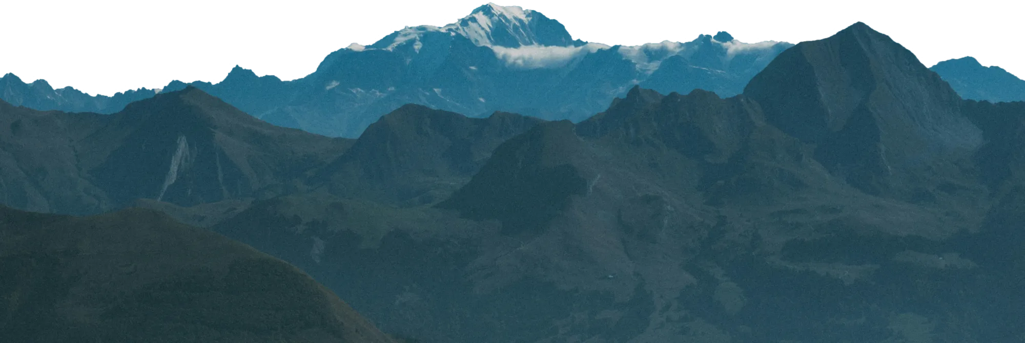 Chaîne de montagnes avec pics enneigés et collines au premier plan sous un ciel clair.