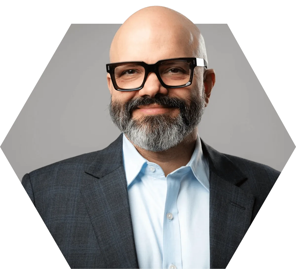Smiling man (Jose-Luiz Moura) with a gray beard wearing black glasses, a light blue shirt, and a dark blazer.