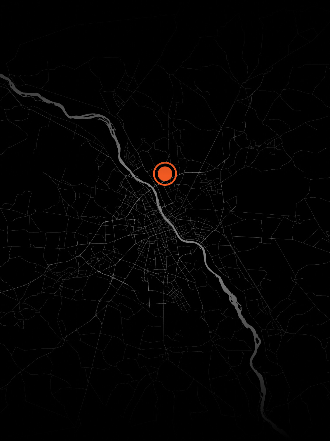 Dark-themed city map with roads and a river, featuring a highlighted orange dot near the city center.