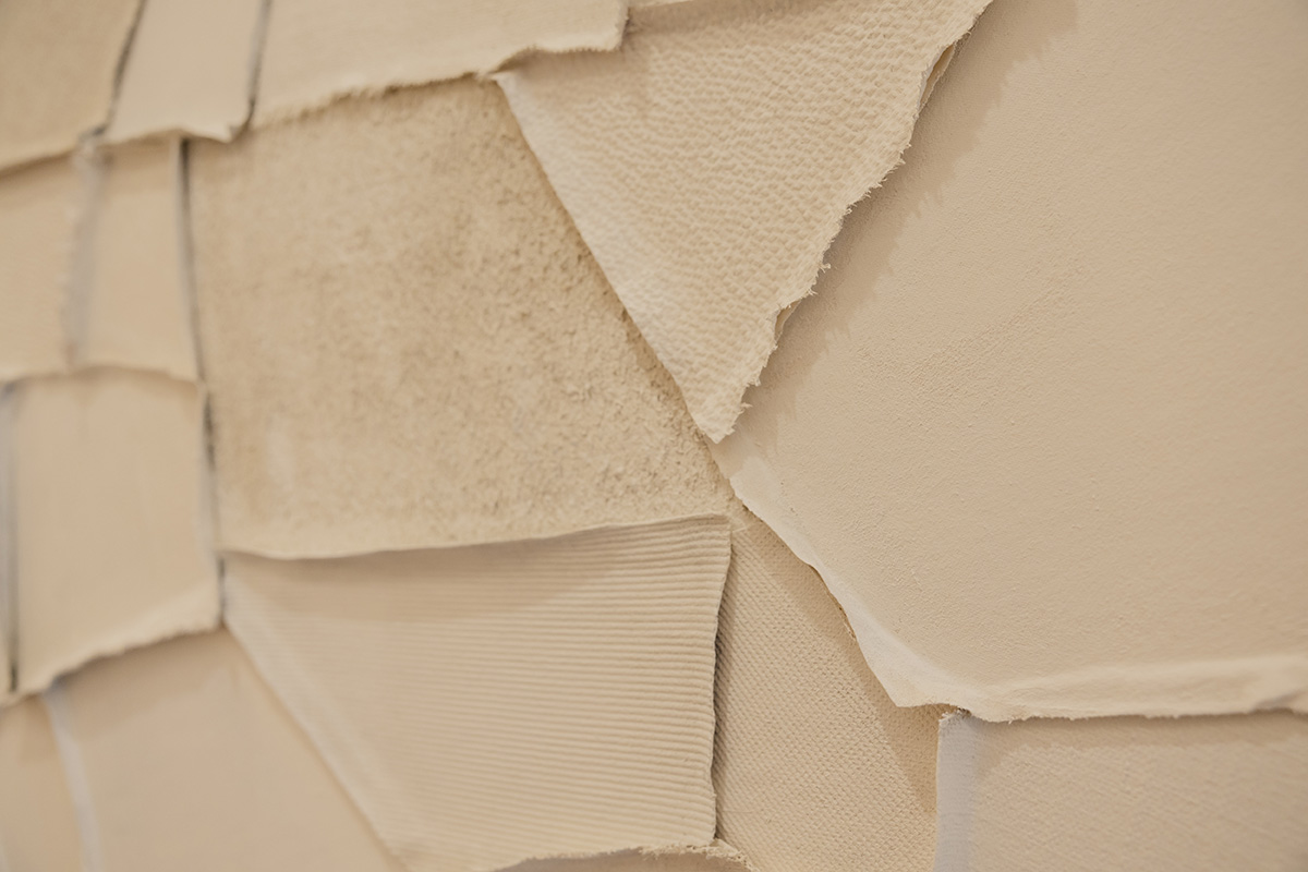 Close-up of various beige textured fabric swatches layered on top of each other.