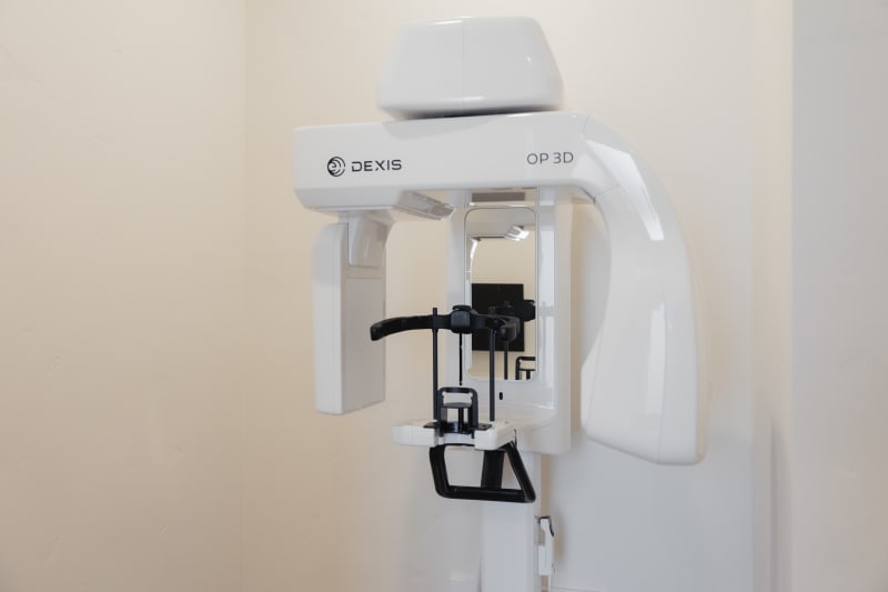 Digital X-ray machine mounted on wall in modern dental operatory
