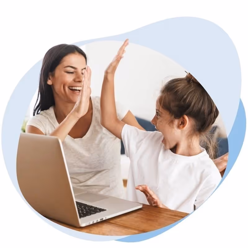 Mutter und Tochter geben vor einem Laptop freudig High Five.