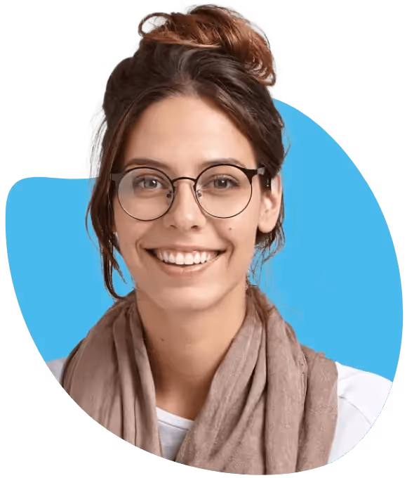 Junge Frau mit Brille und locker gebundenem Haar, die freundlich lächelt, vor blauem Hintergrund.