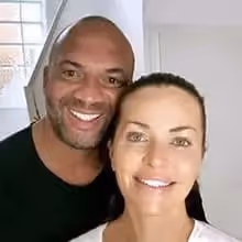 Nahaufnahme eines lächelnden Paares vor einem hellen Hintergrund.