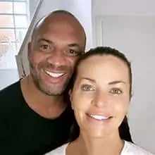 Nahaufnahme eines lächelnden Paares vor einem hellen Hintergrund.