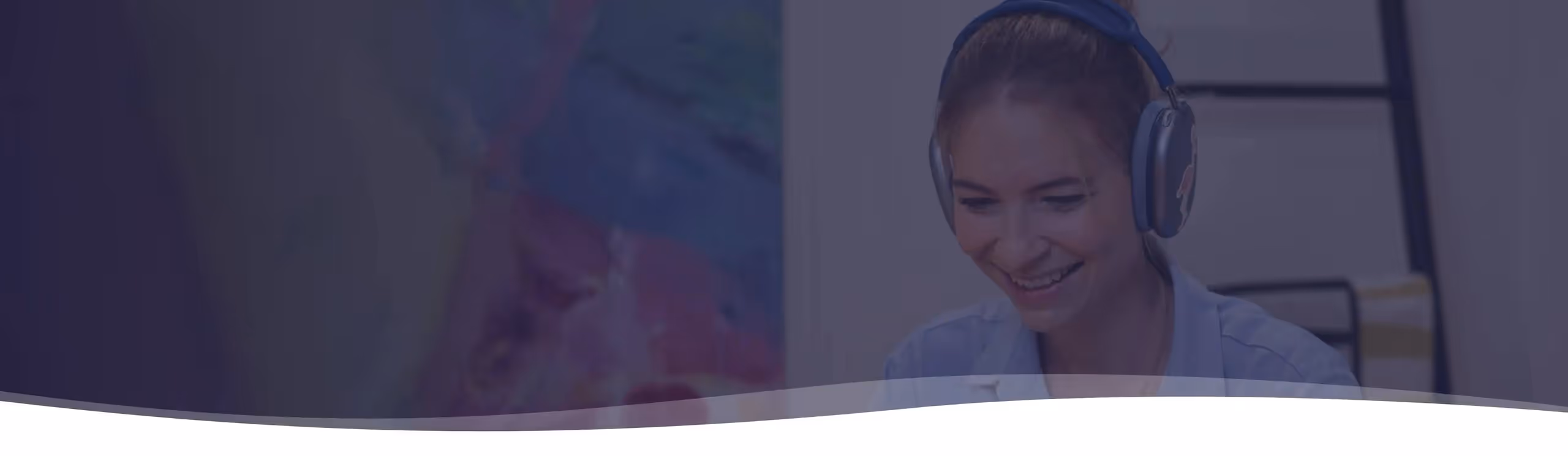 Eine lächelnde Lehrerin trägt Kopfhörer und schaut nach unten.