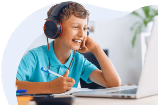 Schüler mit Kopfhörern lächelt und macht sich Notizen vor einem Laptop.